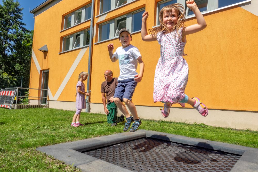 Groß ist die Freude bei den Grundschülern in Mochau: Auf dem Schulhof wurde mit Unterstützung aus der Leader-Förderung ein Bodentrampolin installiert. Der Ortschaftsrat um Ortsvorsteher Ralph Zschörper (hinten) hat sich dafür eingesetzt, dass der lang gehegte Wunsch der Schulleiterin umgesetzt werden konnte. (Foto: Lutz Weidler) Image