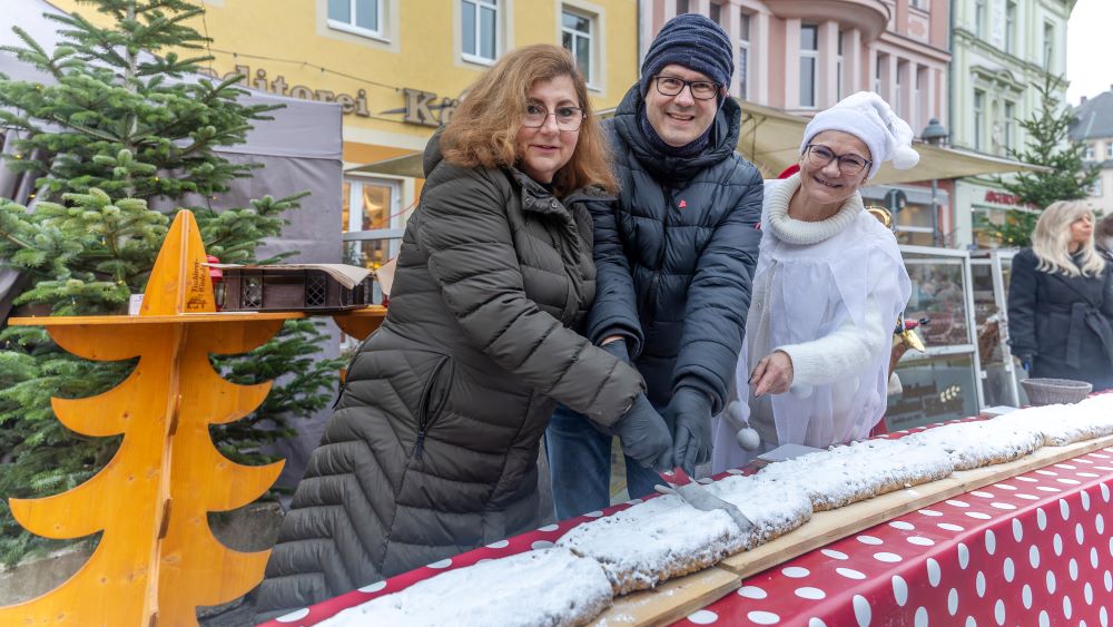 Anschnitt des 31. Döbelner Riesenstollens am Sonnabend mit Franziska Seyffarth (links), Geschäftsführerin der Bäckerei Körner, Oberbürgermeister Sven Liebhauser und Schneeflocke Irinuschka (Irina Schädlich). Die eingenommenen Spenden kommen dieses Mal der Verkehrswacht Döbeln zu Gute. (Foto: Lutz Weidler) Image